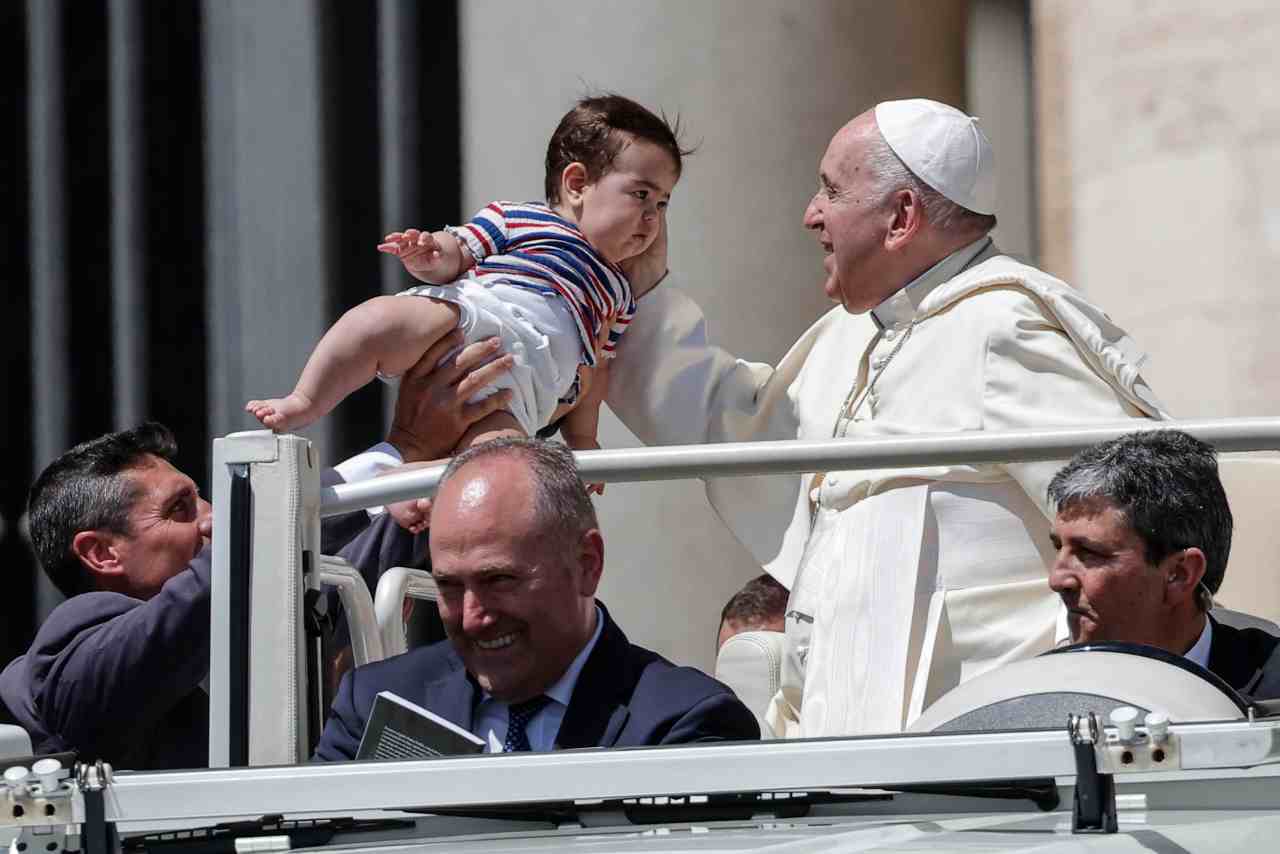 Il Papa saluta un bambino durante l'udienza generale (foto Ansa)
