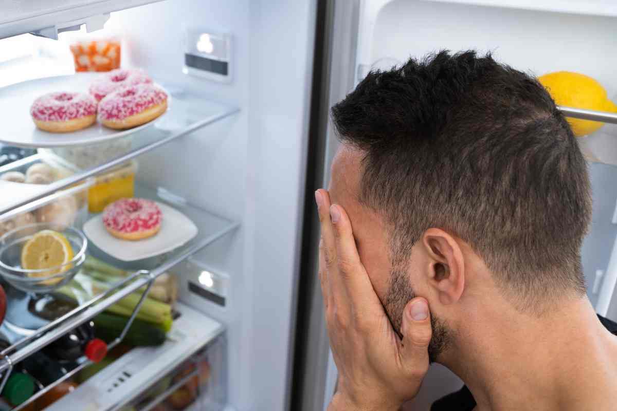 Uomo davanti al frigo 