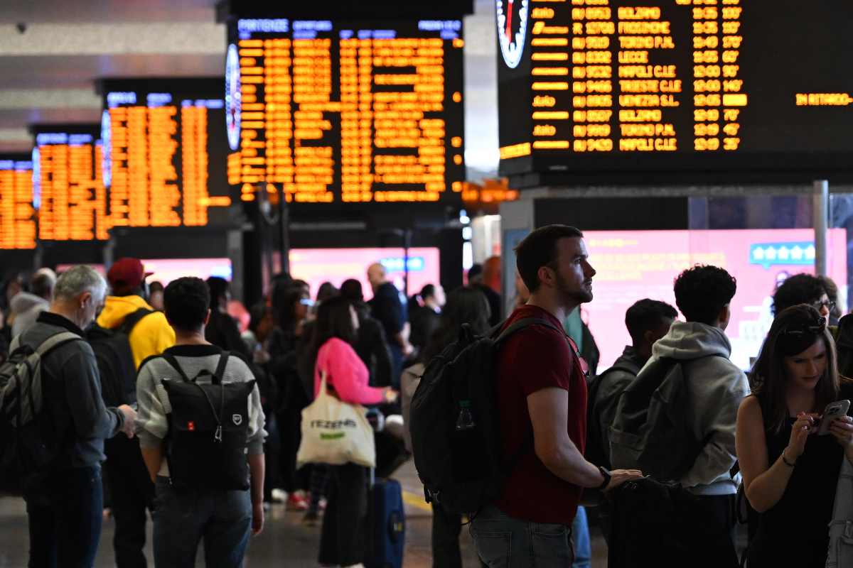 stazione treni e tabelloni con tanta gente