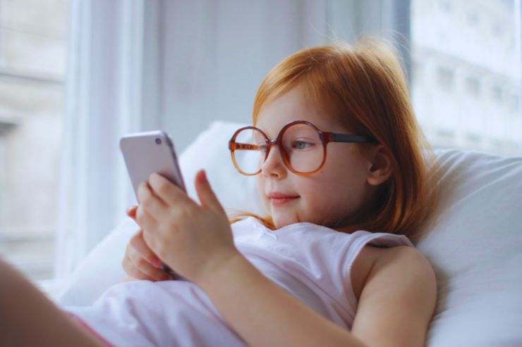 bimba a letto guarda smartphone