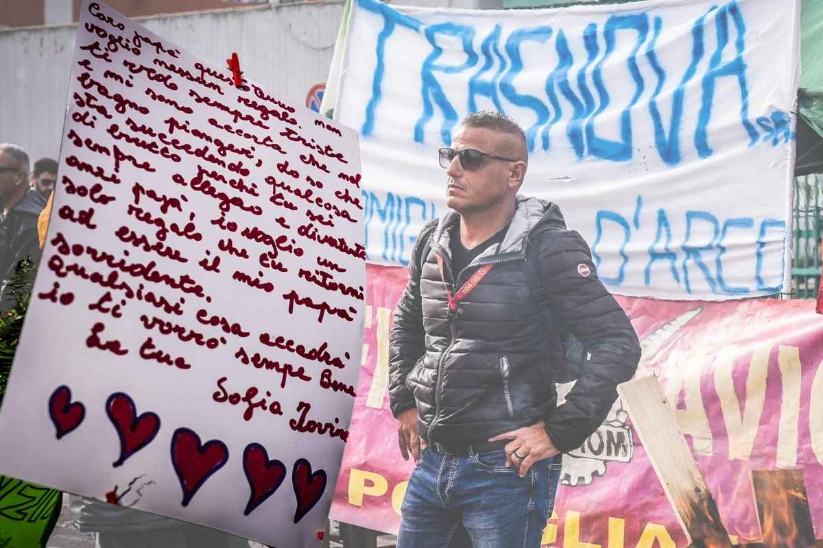 In primo piano la lettera di una figlia a suo padre che è stato licenziato a Pomigliano D'Arco. Sullo sfondo uno degli operai di Trasnova in presidio permanente contro i licenziamenti. 