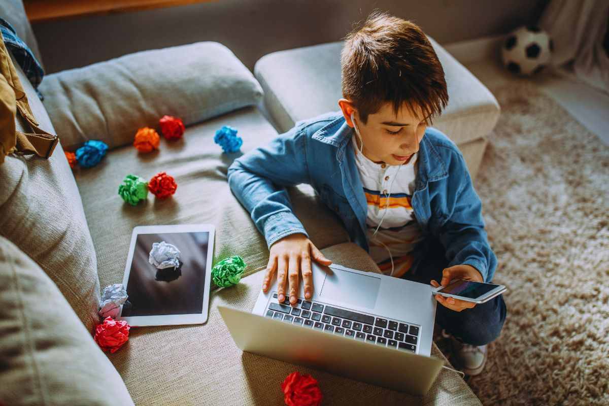 bambino con computer tablet e smartphone