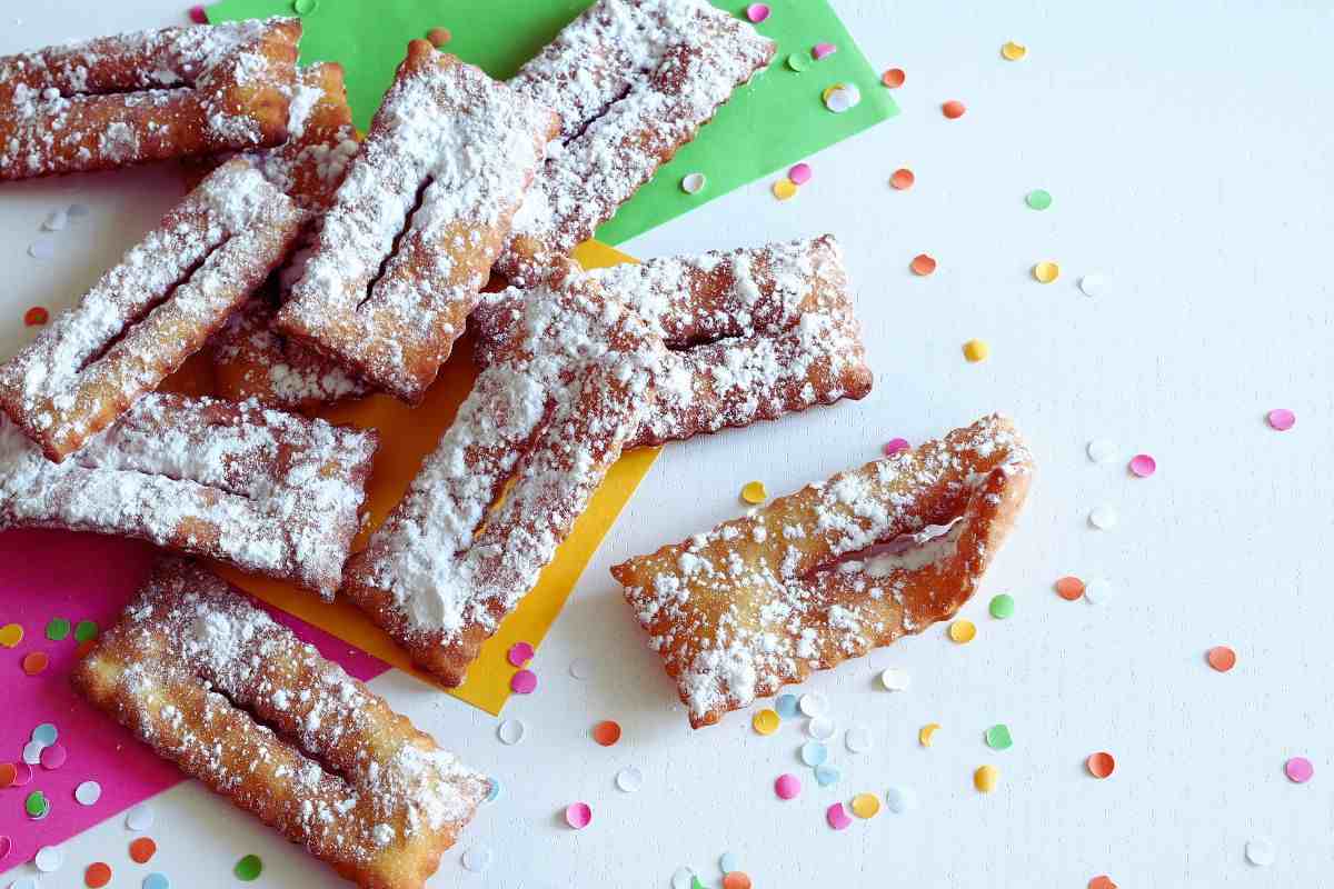 delle chiacchiere su un tavolo con coriandoli e fogli colorati