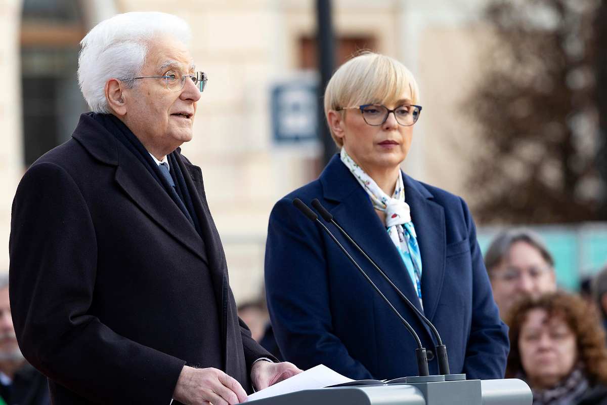 sergio mattarella al fianco di una donna in piedi durante un discorso
