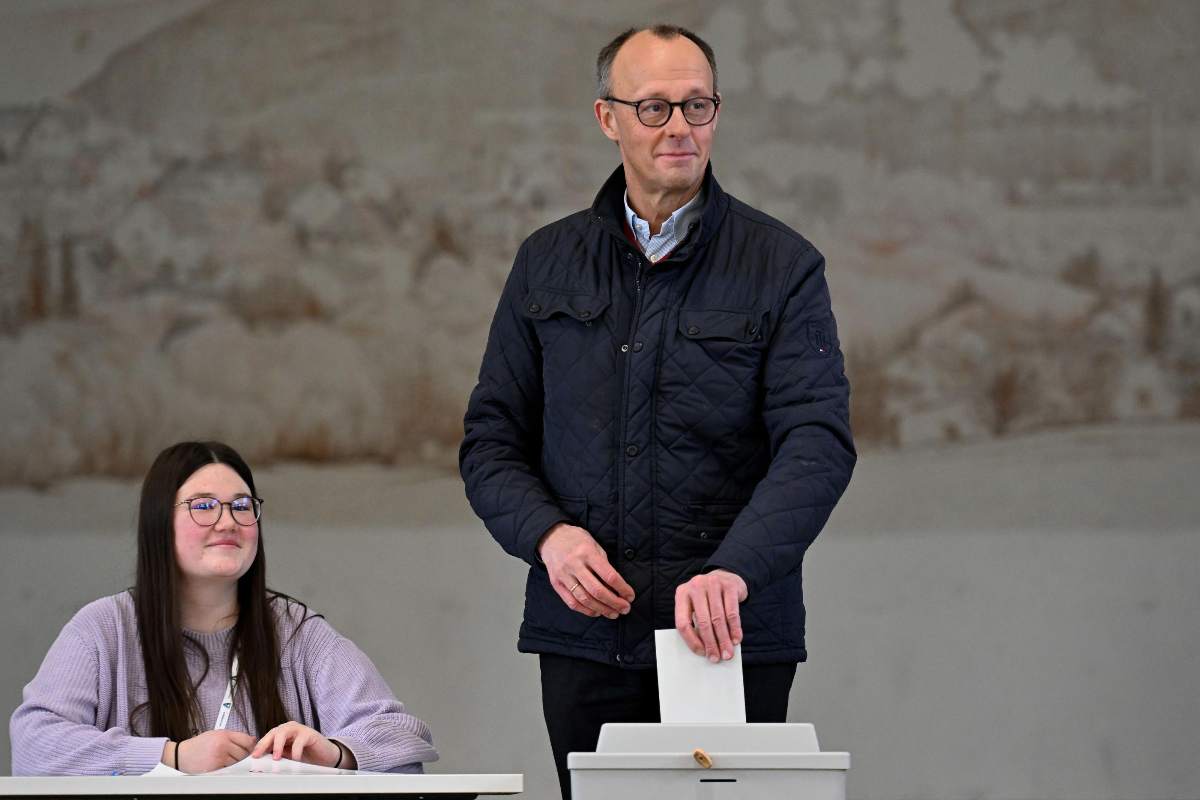 merzi che deposita la scheda del suo voto e una donna