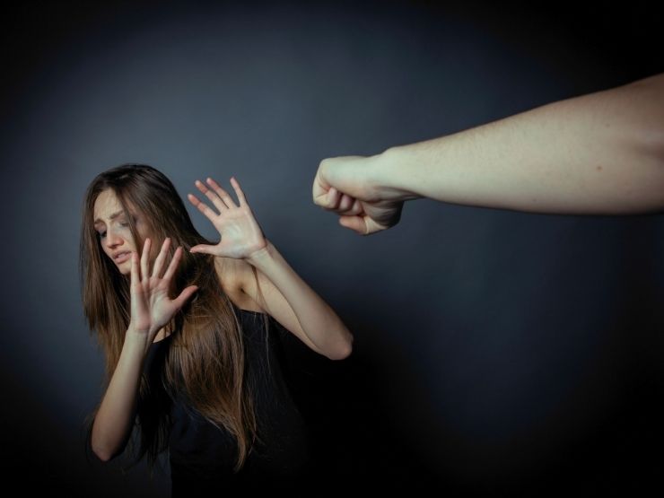 Una donna contro il muro mentre subisce percosse da un uomo