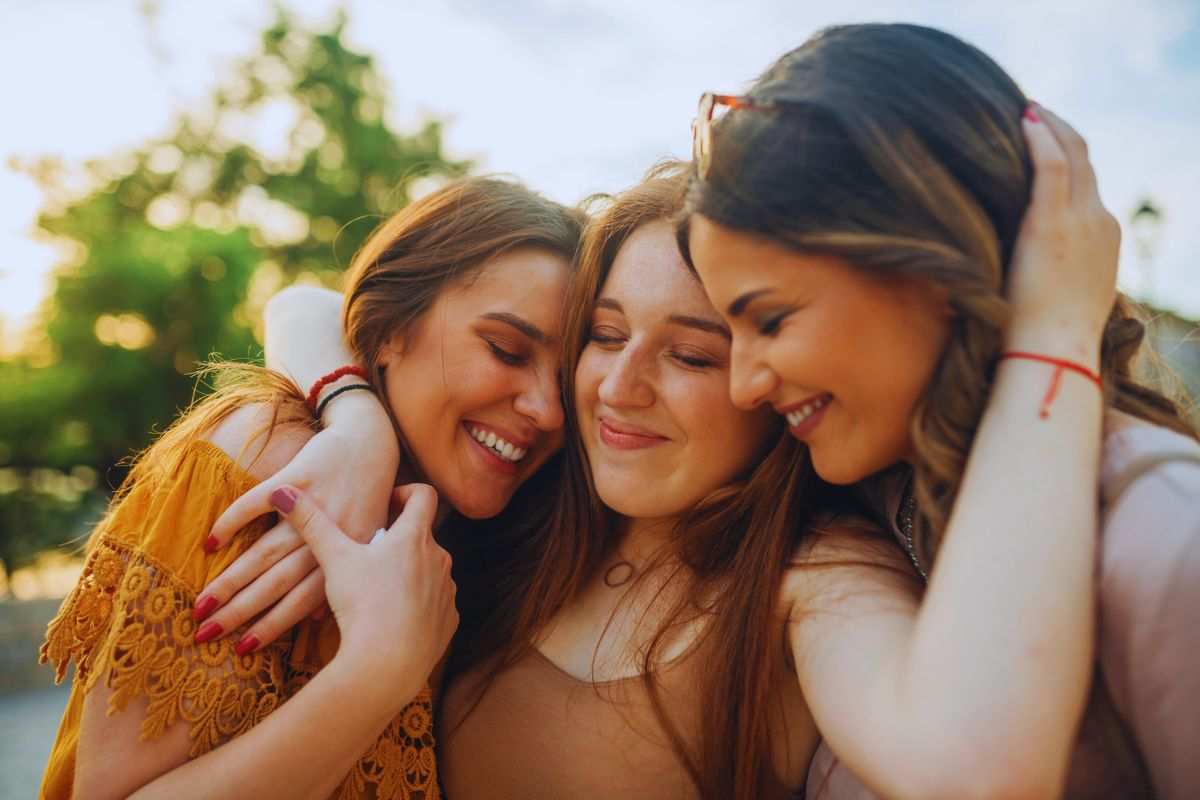 tre ragazze giovani si abbracciano