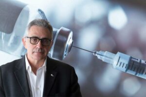 fabrizio pregliasco e una siringa che prende liquido