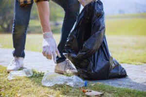persona raccoglie spazzatura per strada