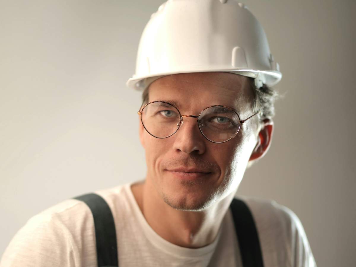Un operaio con un casco bianco in primo piano