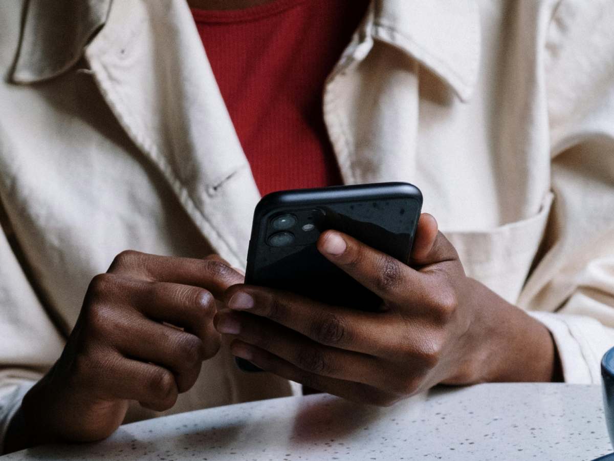 Uomo con un telefono in mano mentre scrive un messaggio