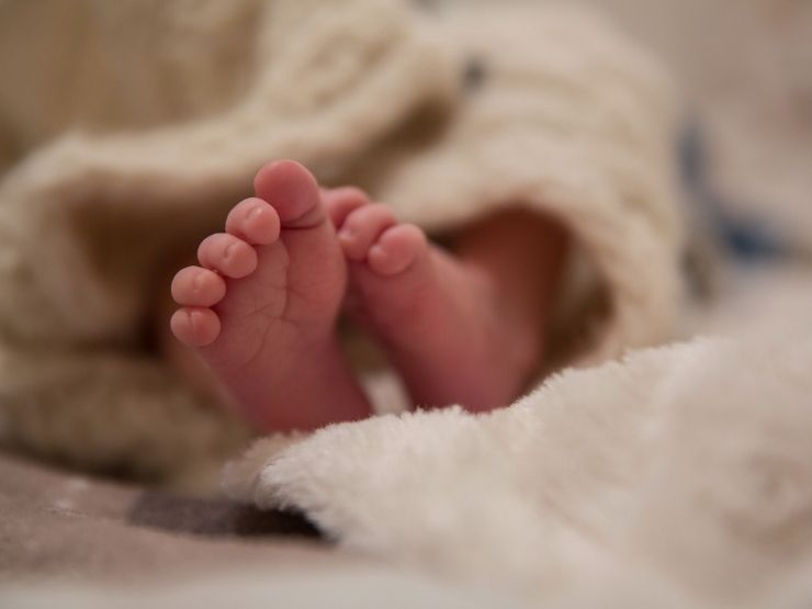 Un neonato nella culletta con i piedini scoperti