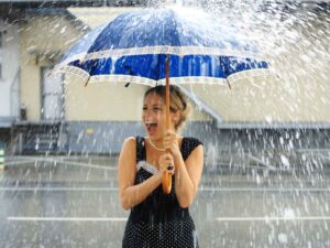 Una ragazza sorride sotto la pioggia in primavera