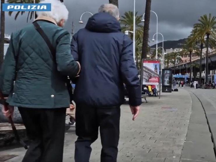 Due anziani camminano per strada a braccetto