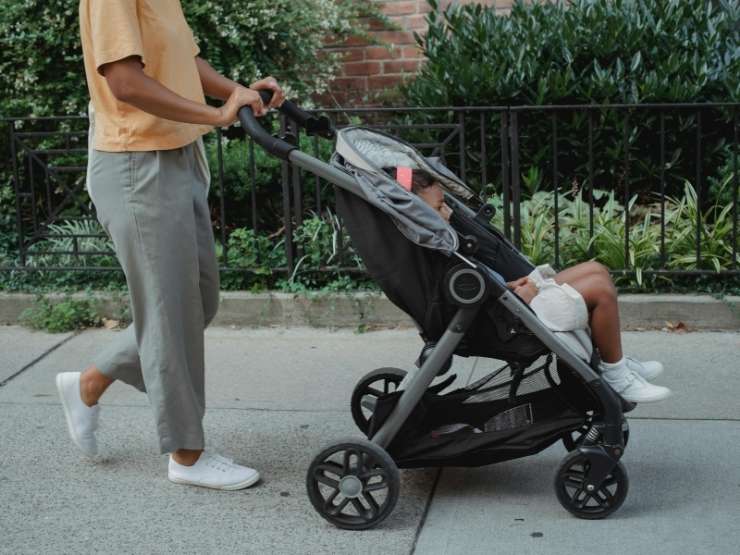 Una padre passeggia con il figlio nel passeggino
