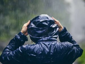 Una persona si ripara dalla pioggia con l'impermeabile