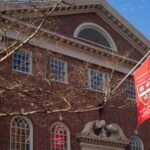 Una foto esterna dell'Università di Harvard con una bandiera esposta