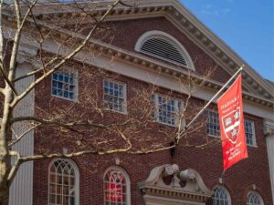 Una foto esterna dell'Università di Harvard con una bandiera esposta