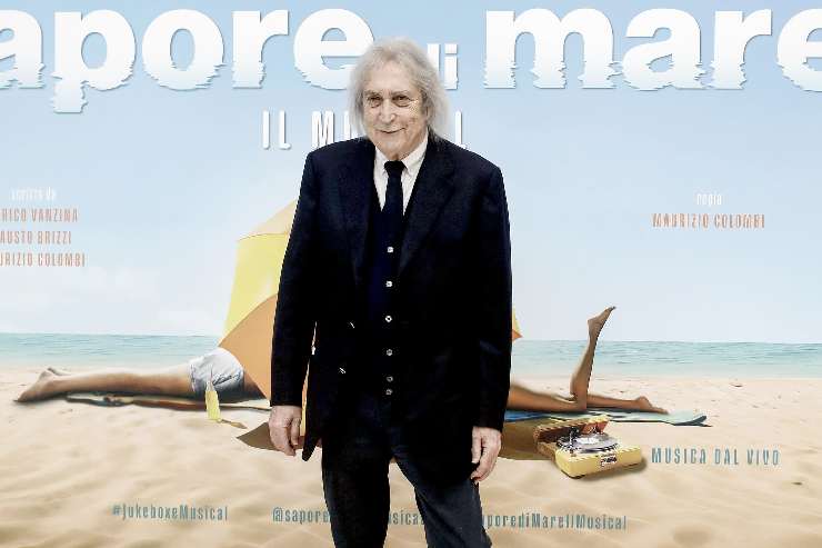 enrico vanzina davanti al cartellone di sapore di mare il musical