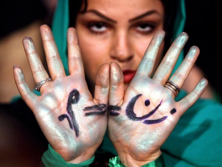 Una donna iraniana sostenitrice del candidato Mir-Hossein Mousavi mostra la scritta ''le donne dovrebbero avere gli stessi diritti degli uomini'' a Teheran