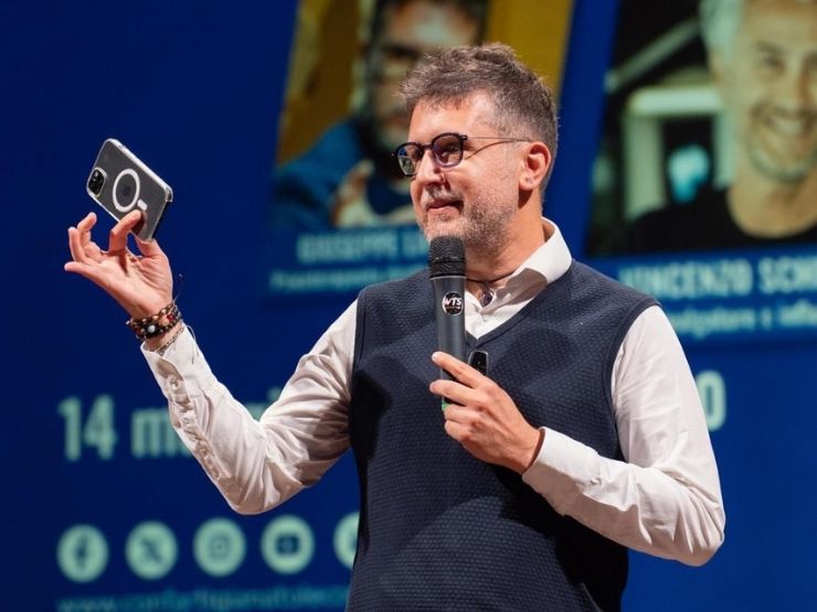 Giuseppe Lavenia, presidente dell'associazione Di.Te durante un dibattito pubblico con in mano uno smartphone