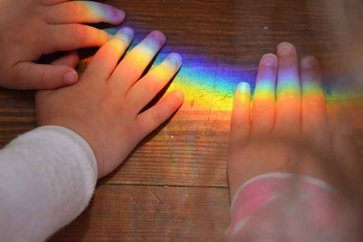 Mani di bambini maltrattati su cui c'è un arcobaleno
