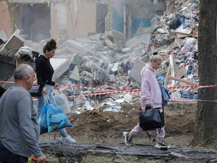 Cittadini ucraini passeggiano tra le macerie a Kiev