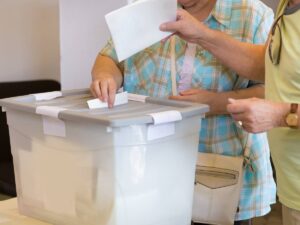 Due cittadini consegnano la scheda dopo aver votato