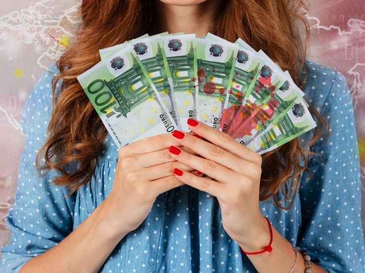 Una donna che tiene in mano banconote da cento euro insanguinate, un'immagine della campagna contro il money mule dell'Europol