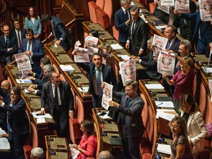 I senatori del Pd espongono la Costituzione capovolta dopo l'ok al ddl Nordio