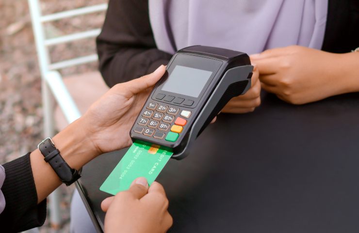 Negoziante infila la carta nel Pos