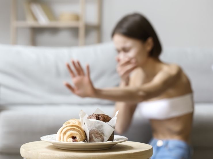 Una ragazza con disturbo alimentare allontana una brioche
