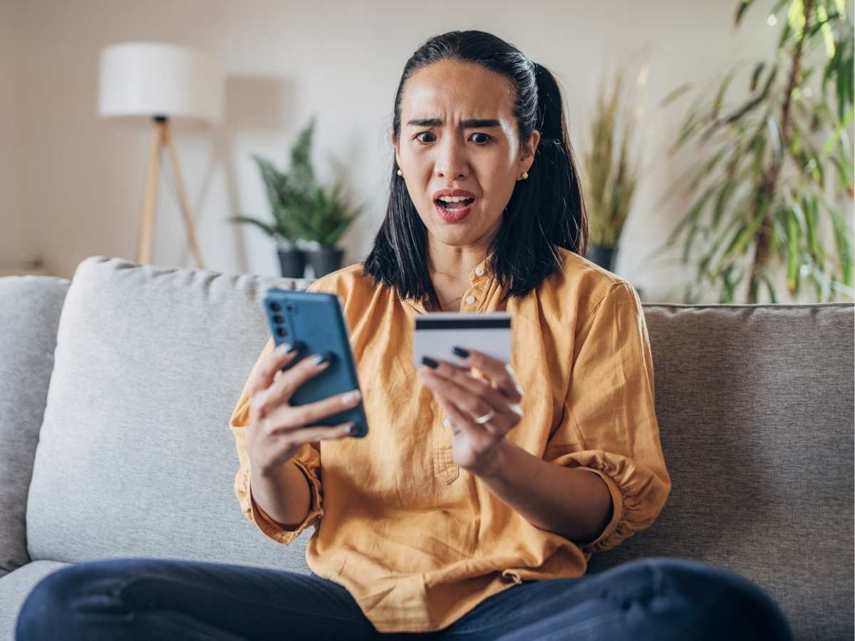 Una ragazza seduta sul divano al computer ha appena scoperto di essere stata truffata online
