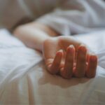 La mano di una donna malata sul letto di un ospedale