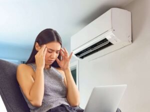 sfondo aria condizionata accesa e ragazza con mal di testa