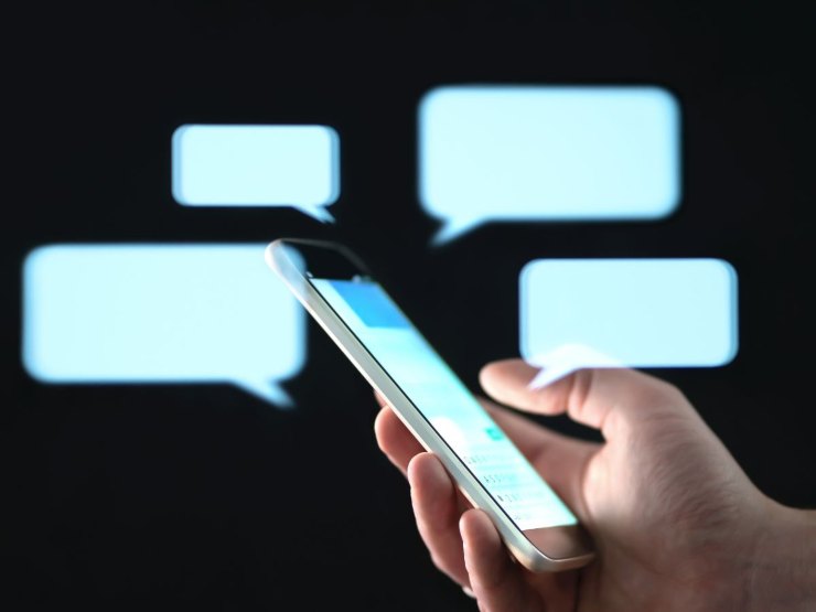 mano con cellulare e chat