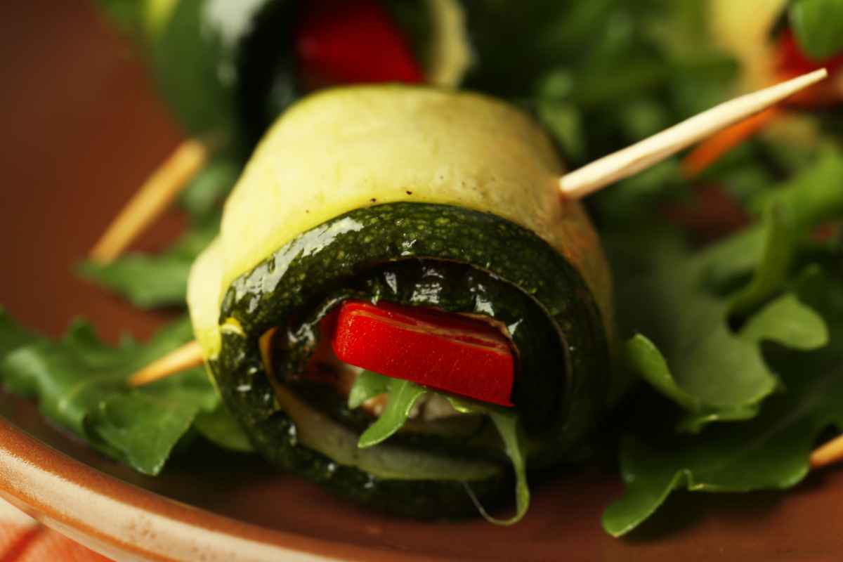 Primo piano di un involtino di zucchine grigliate con pomodorini all'interno