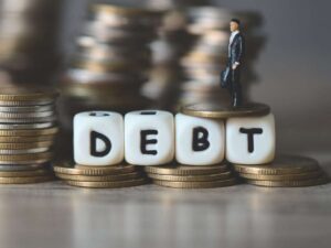 Monete e la scritta "Debito" in inglese