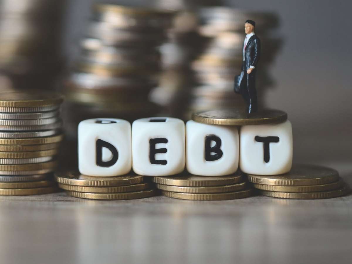 Monete e la scritta "Debito" in inglese