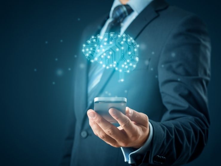 Una mano umana con la proiezione dallo smarphone di un cervello artificiale