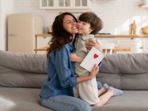 La madre abbraccia il figlio dopo che lui le ha dato una lettera che ha scritto