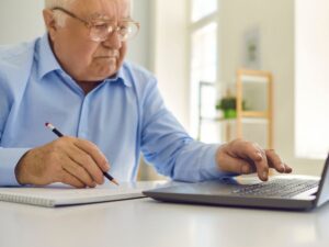 Pensionato al computer fa i conti per la pensione