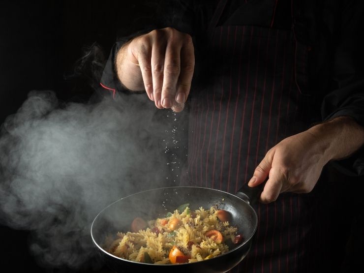 Uno chef usa sale da cucina