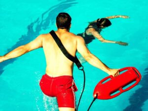 Un bagnino si tuffa in una piscina per salvare una persona