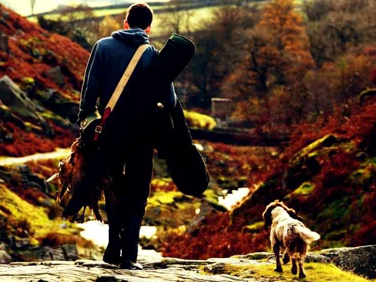Un cacciatore in Italia insieme al suo cane da caccia