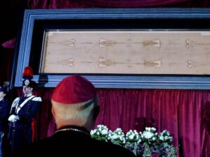 Un cardinale in preghiera durante un'ostensione della Sindone