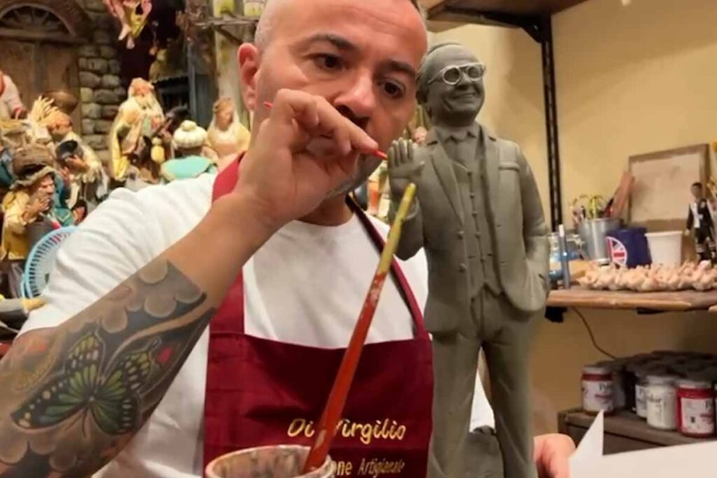 Artigiano del presepe con statuina di Pippo Baudo