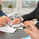 sfondo uomini che parlano davanti documenti e lente di ingrandimento in mano