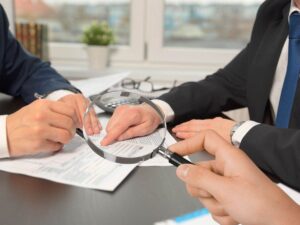 sfondo uomini che parlano davanti documenti e lente di ingrandimento in mano
