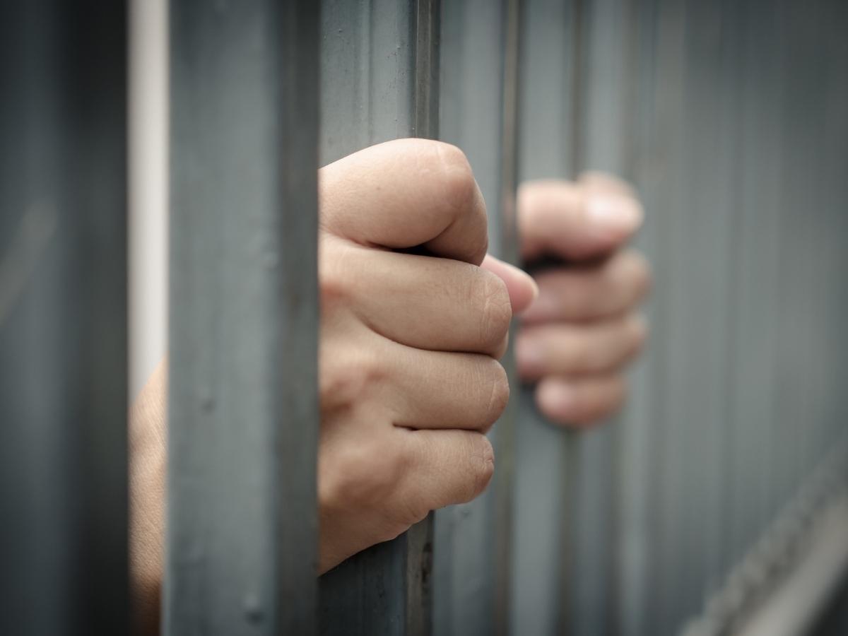 Detenuto in cella con le mani sulle sbarre
